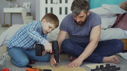 Boy and Man Work Together on Wood Project