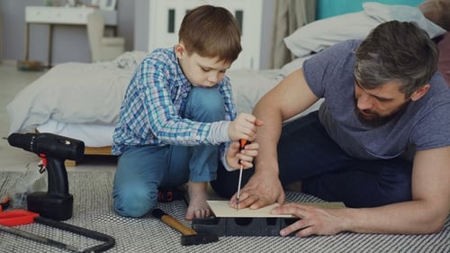 Child and Adult Work on Wood-Working Project Together
