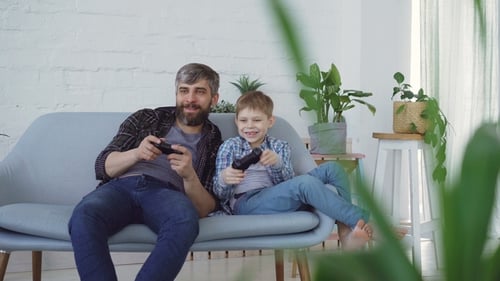 Father and Son Playing Video Games at Home