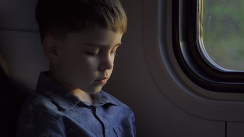 Pensive Child Sits Quietly by the Window