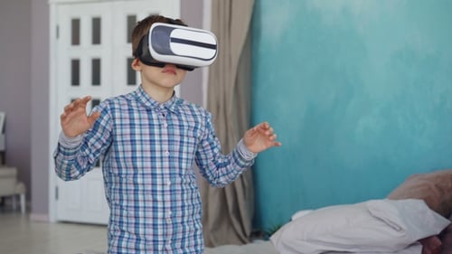 Boy Using Virtual Reality Headset in Bedroom