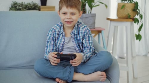 Young Boy Playing Video Games on Couch