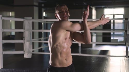 Athletic Man Stretching in Gym Before Exercise