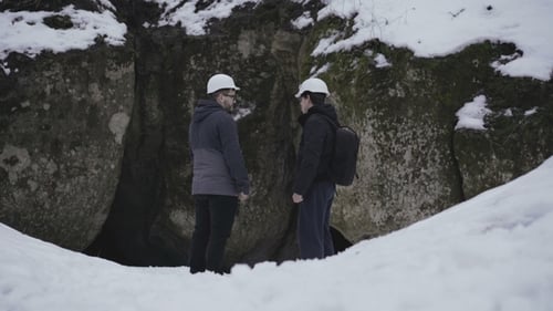 Dos espeleólogos entran en la cueva en el bosque