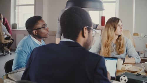 Multiethnic People Sit at the Table in Modern Office. Company Employees Listening To Each Other on