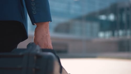 Man Carrying Hard Case Through City