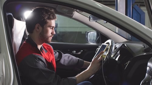 Auto Mechanic Using Tablet to Diagnose Vehicle