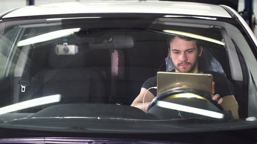 Young Man Using Tablet in Vehicle Cab