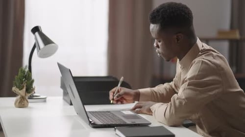 Young Adult Working At Home on Laptop