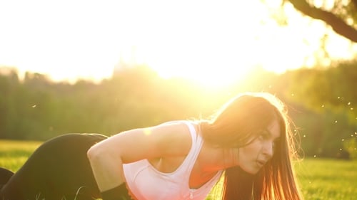 Fit Woman Exercising Push Ups in Golden Park