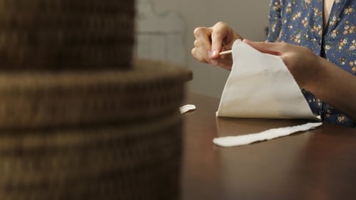 Woman Crafting with White Fabric at Table