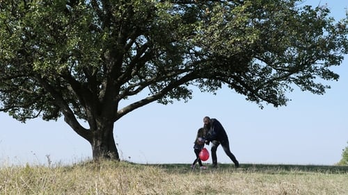 Family Embracing Under Large Tree on Grassy Hill