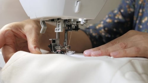 Sewing Machine Stitching Fabric in Close Up Detail