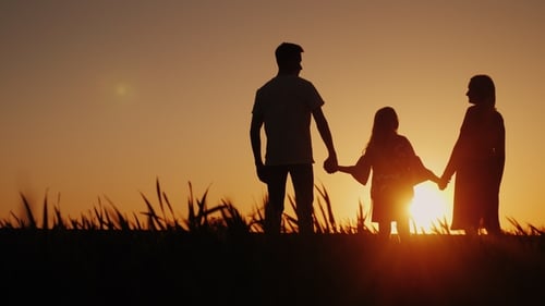 Silhouette Family Holding Hands at Sunset