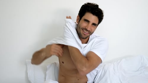 Handsome Man Takes Off White T-Shirt in Bed