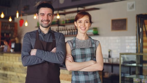 Happy Good-looking Waiters Are Standing Inside New Cafe with Hands Crossed, Laughing and Looking at