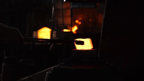 Glowing Metal Being Forged in Dark Factory