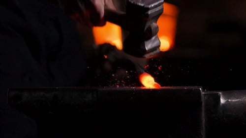 Blacksmith Shaping Red-Hot Metal on Anvil With Hammer
