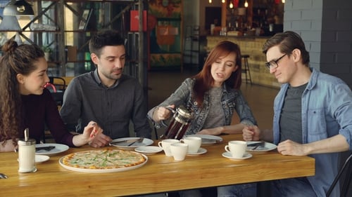 Young Adults Enjoying Pizza and Tea Together