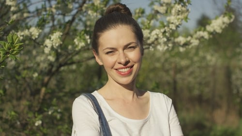 Smiling Beautiful Woman Near Blossoming Tree
