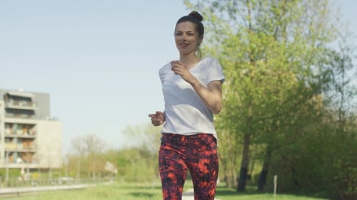 Woman Jogging on Park Path