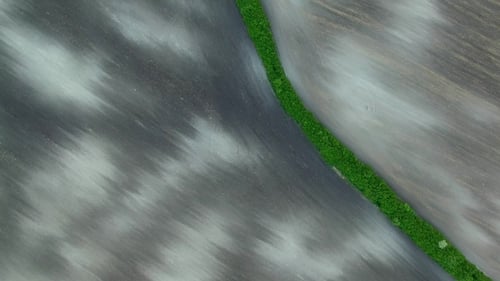 Texture of Plowed Field, Aerial View Green Border Between Two Plowed Field Before Planting.