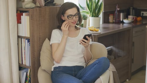 Woman Listening to Music on Smartphone Indoors