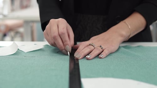 Drawing Sewing Pattern with Chalk on Green Fabric