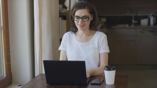 Woman Uses Laptop at Home, Desk and Coffee