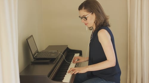 Woman Playing Digital Piano at Home, Side View