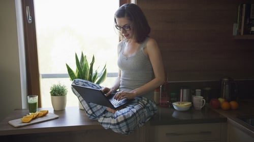 Woman Works on Laptop in Sunny Kitchen