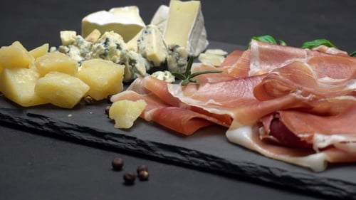 Tranches de prosciutto ou de jamon et fromage sur fond de béton