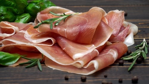 Sliced Prosciutto or Jamon Meat on Wooden Background