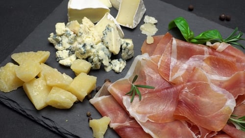 Tranches de prosciutto ou de jamon et fromage sur fond de béton