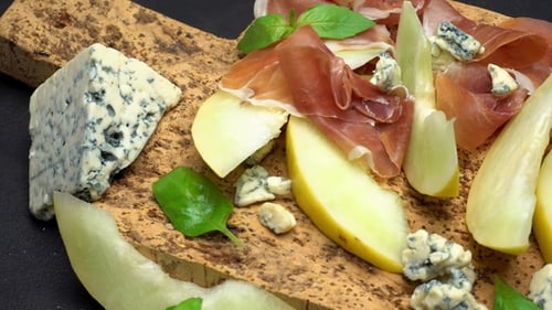 Tranches de prosciutto et de melon sur une planche en liège
