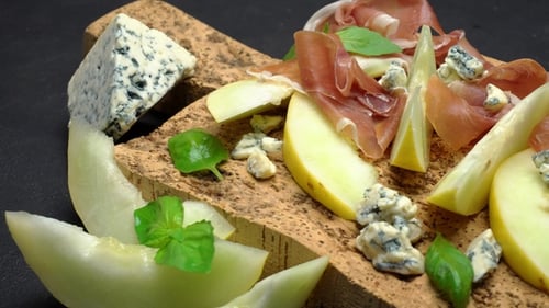 Tranches de prosciutto et de melon sur une planche en liège
