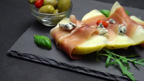 Tranches de prosciutto et de melon sur une planche en pierre
