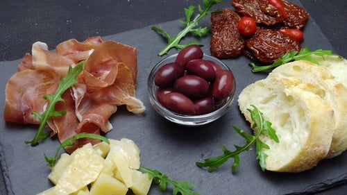Tranches de prosciutto ou de jamon et fromage sur fond de béton