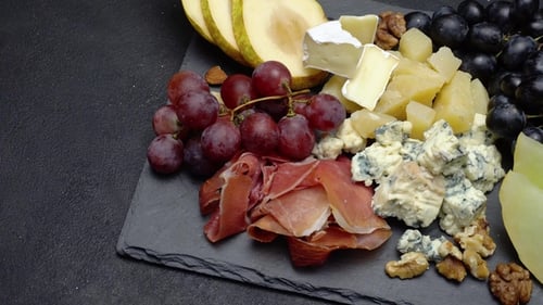 Assiette de viande et de fromage Snack antipasti avec prosciutto, melon, raisins et fromage