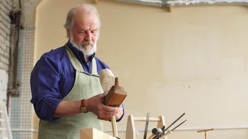 Serious Mature Man with Grey Hair, Moustache and Beard Thinking About Further Plans of Building