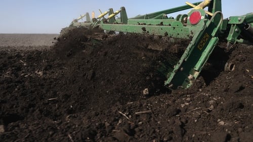 Farm Machine Plowing Soil in Rural Field