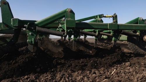 Tractor Tiller Cultivating Field on Sunny Day