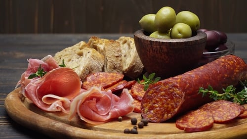 Tranches de saucisse au prosciutto et au salami sur une planche de bois