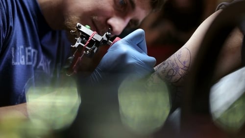 Professional Artist Making Tattoo in Salon.