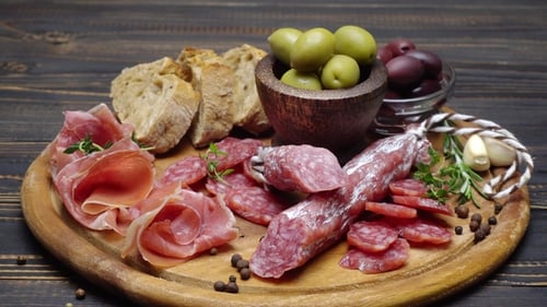 Tranches de saucisse au prosciutto et au salami sur une planche de bois