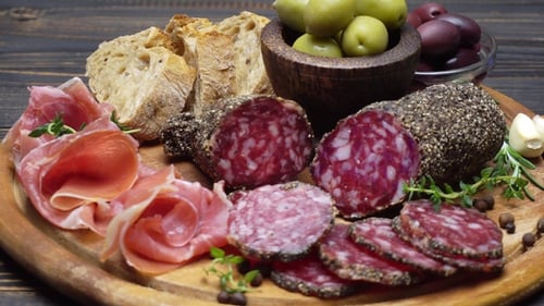 Tranches de saucisse au prosciutto et au salami sur une planche de bois
