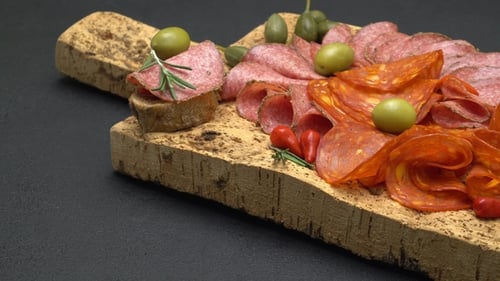 Delicious Meats Arranged on Cork Board with Olives