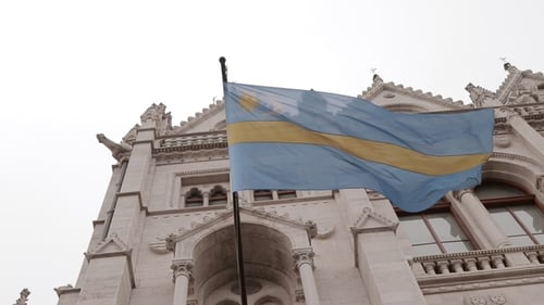 Old Building With Flag On Cloudy Day