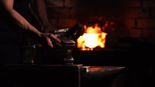 Blacksmith Shapes Hot Metal in Dark Workshop