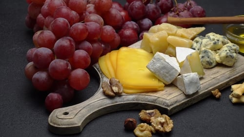 Close Up of Cheese Board with Grapes and Honey
